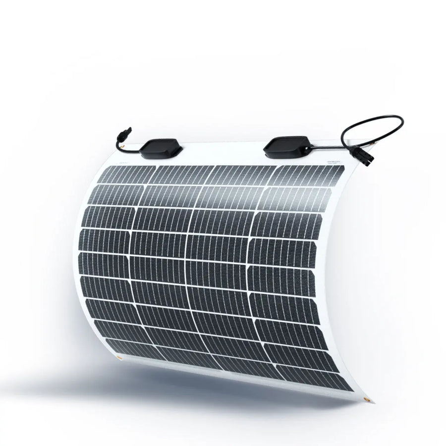 Renogy 50W flexible monocrystalline solar panel photographed curved to show its bendability, ETFE laminate surface exposing a 4-by-9 grid of monocrystalline cells with two black MC4 junction boxes at the top edge and brass grommets at each corner.